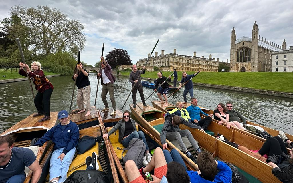 People in six punts, punting along the river Cam